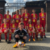 : Een teamfoto voor de poort van het stadion